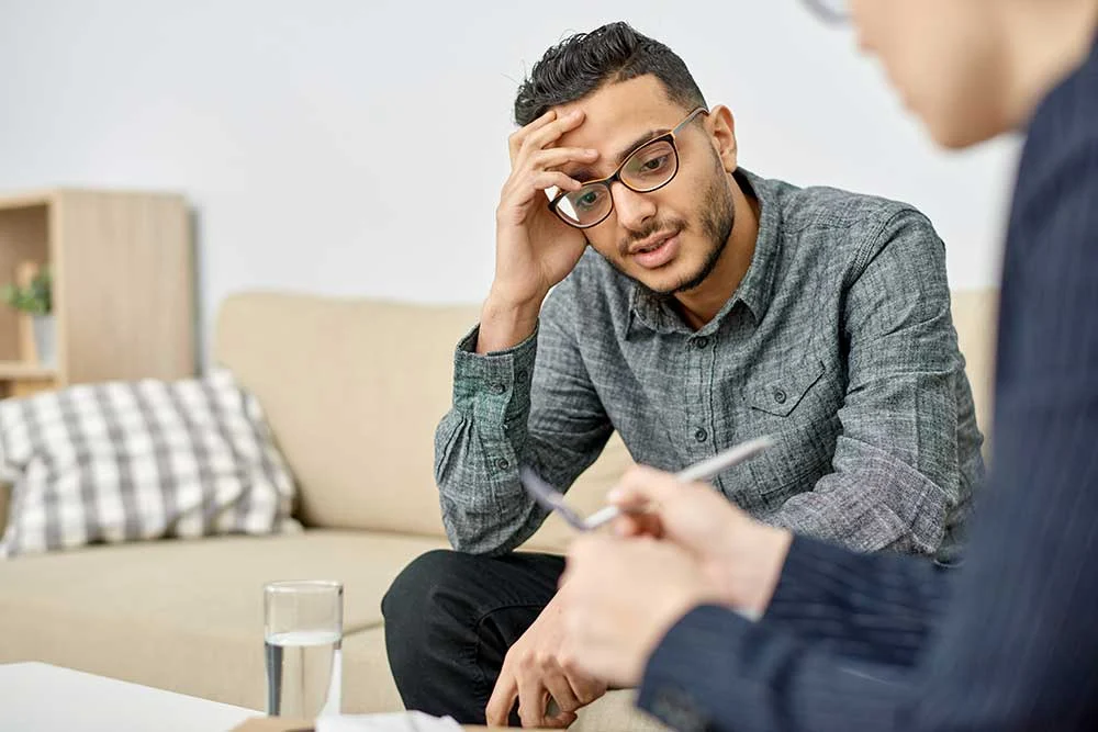 AdobeStock_1988493131 man in individual therapy talking to therapist about addiction treatment