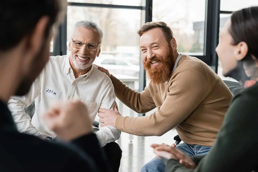AdobeStock_579814191 men supporting each other in recovery meeting for alcohol addiction